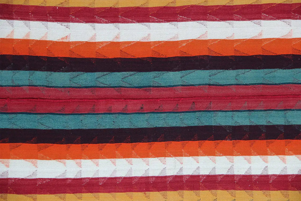 Close-up of a Jajim rug with red, green, and orange horizontal stripes