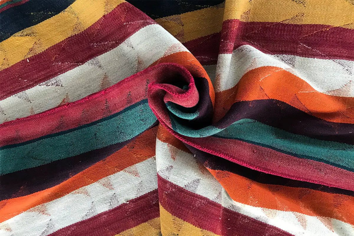 Jajim rug rolled up: multicolored stripes in red, green, blue, and ochre
