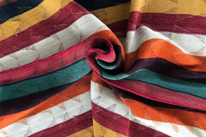 Jajim rug rolled up: multicolored stripes in red, green, blue, and ochre