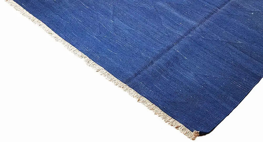 Blue kilim rug with fringes, woven texture in the corner