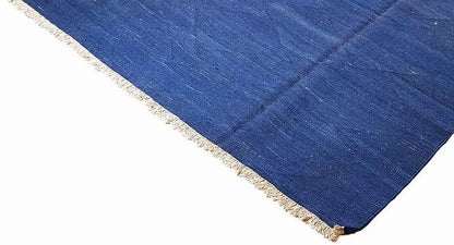 Blue kilim rug with fringes, woven texture in the corner