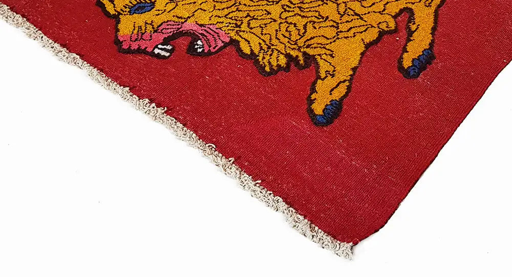 Carpet corner with a red background and yellow lion motif, side fringe