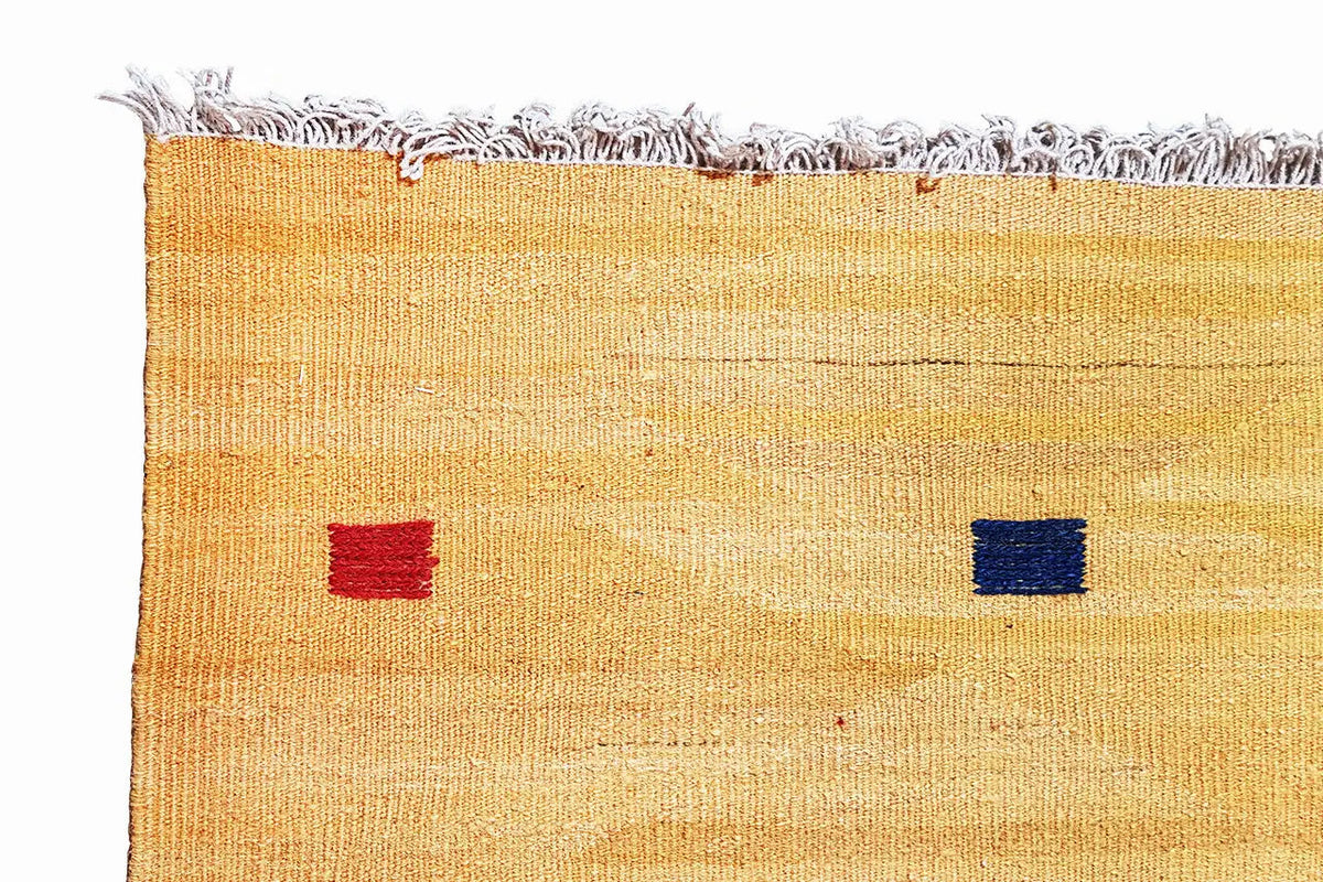 Ochre kilim rug with blue and red motif squares, hand-finished fringes