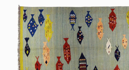 Multicolored kilim with fish motifs and fringe, on light blue