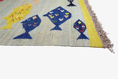 Kilim corner with fish motifs in blue, yellow, and red, with fringes along the edge