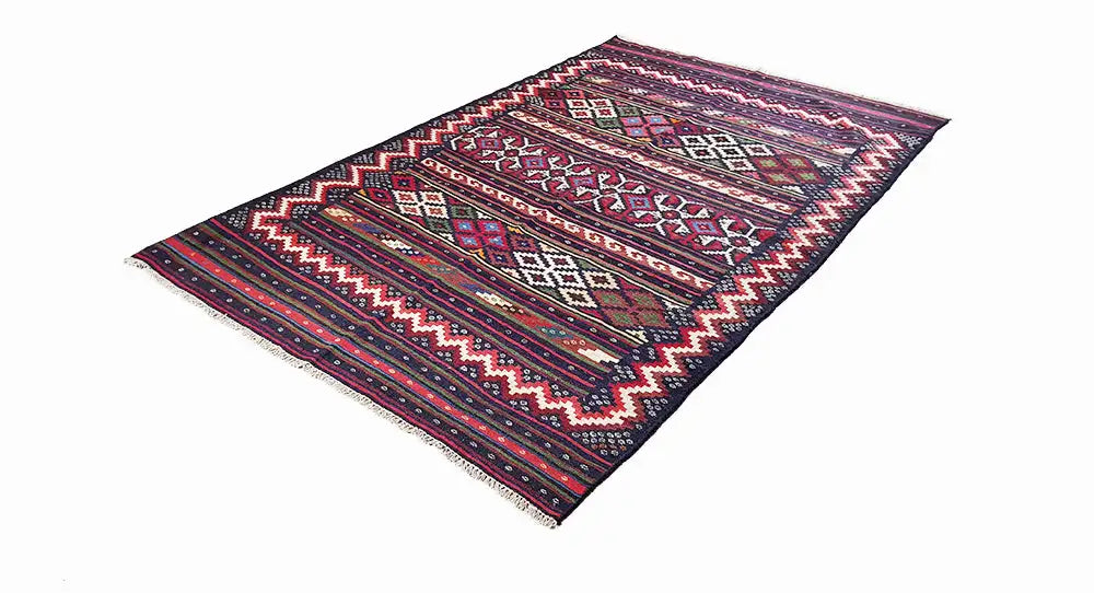 Kilim rug in an angled view with diamond, zigzag, and striped patterns, dark blue