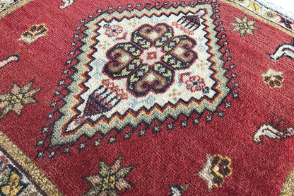 Poschti Qashqai rug, detail: central ornament on a red ground with a zigzag border