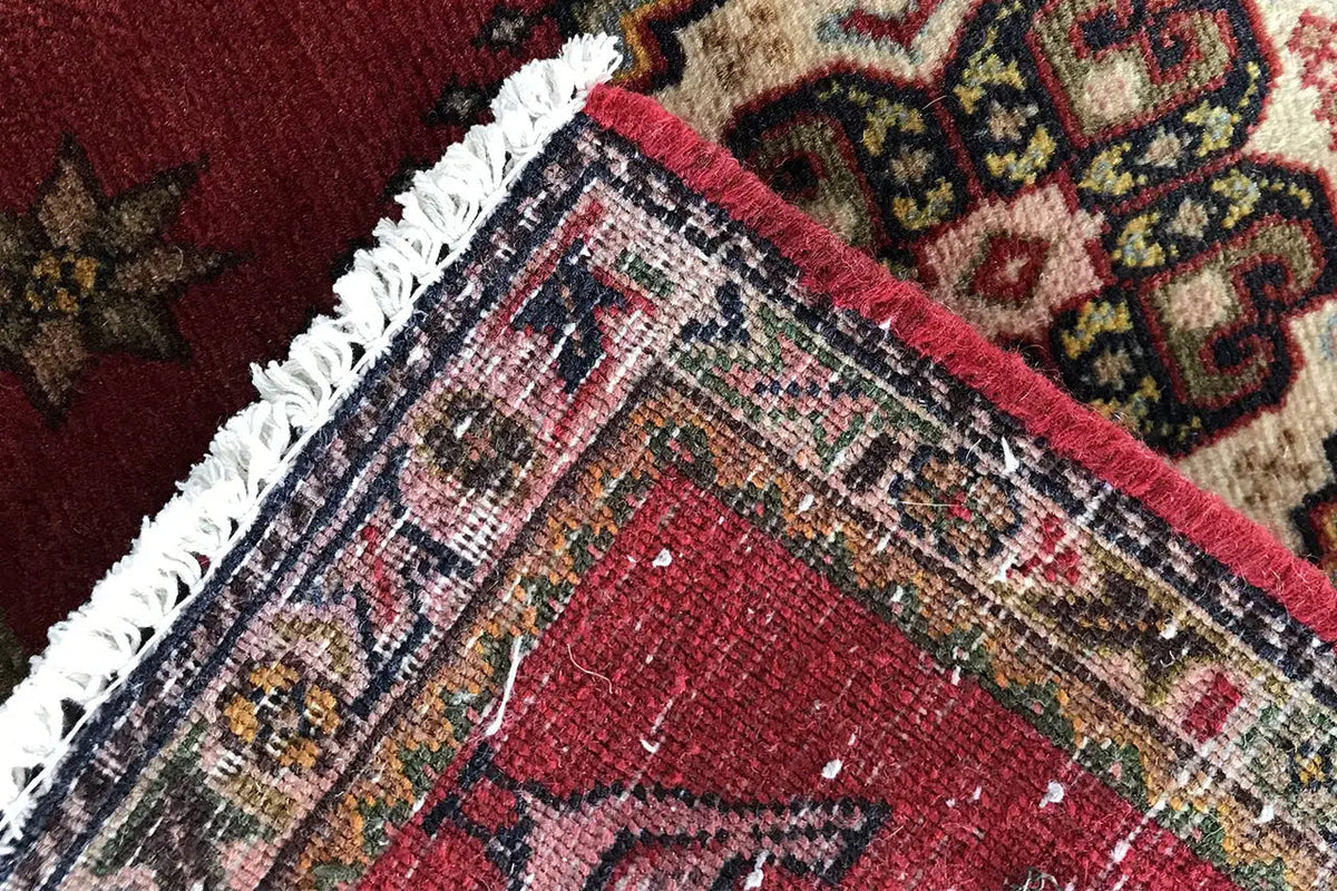 Poschti Qashqai rug, close-up of the weave with a red-and-beige pattern and border