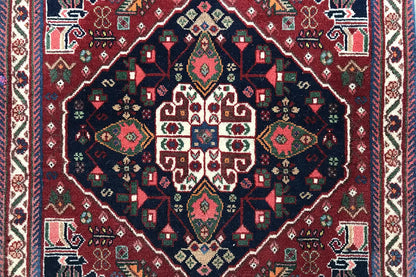 Detail view: carpet pattern with a symmetrical medallion in blue, red, green, and beige