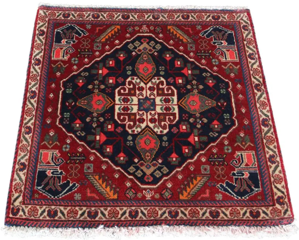 Qashqai rug by Poschti: red oriental rug with a dark blue medallion and fringes.