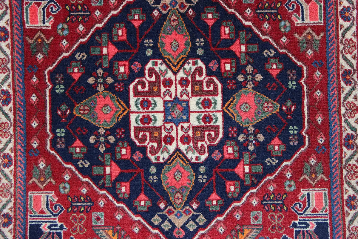 Qashqai rug by Poschti: Detail of the geometric pattern with a red and dark blue color palette.