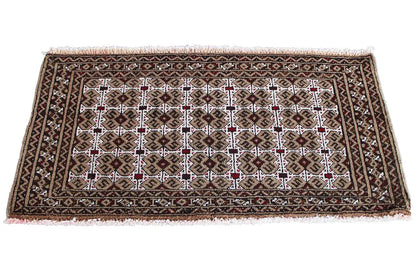 Turkmen rug with a geometric pattern in dark brown, beige, white, and red accents