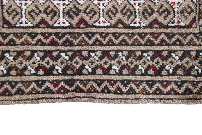 Detail of a Turkmen carpet: horizontal patterned bands in dark brown, beige, white, and red