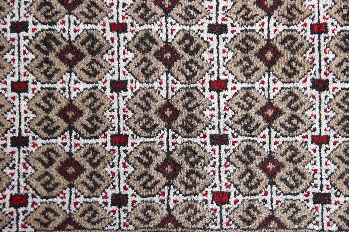 Close-up of a Turkmen rug: multiple diamonds and medallions in gray-beige and white