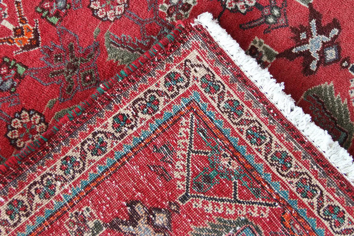 Close-up: red carpet fabric with a fine pattern and colorful accents