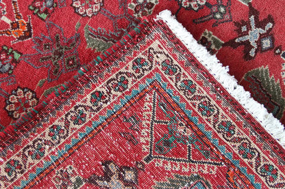 Close-up: red carpet fabric with a fine pattern and colorful accents