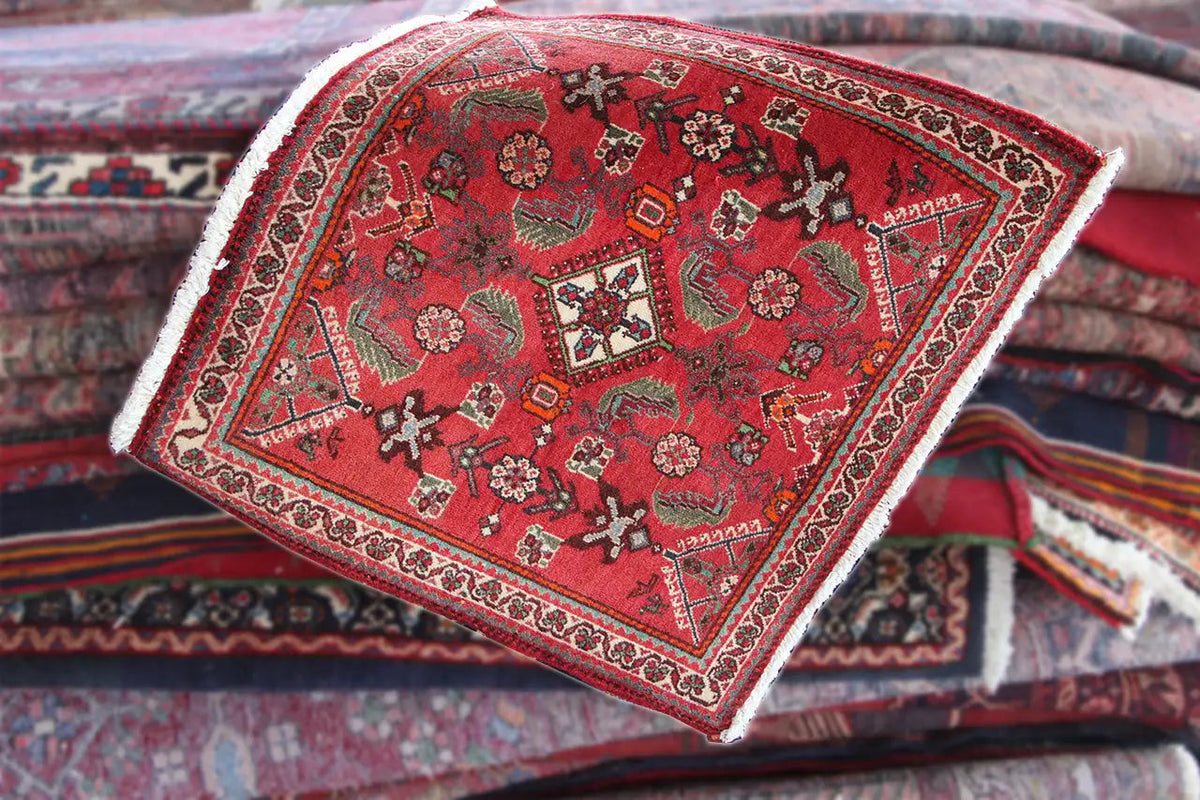 Red carpet on folded textiles, with border and white fringes