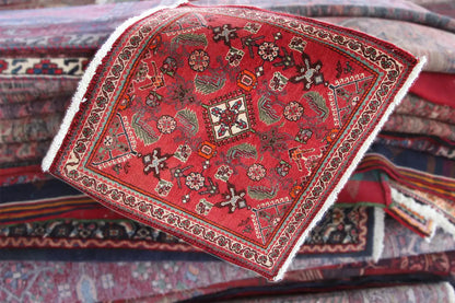 Red carpet on folded textiles, with border and white fringes