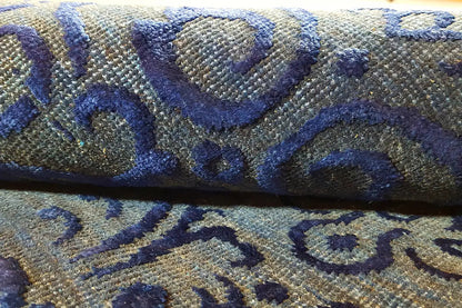 Close-up of a rug: blue ornamental design on a beige background, woven texture