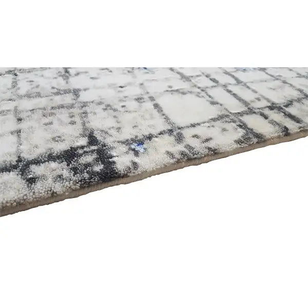 Carpet corner with a vintage grid pattern and abstract blue patches, with a visible edge