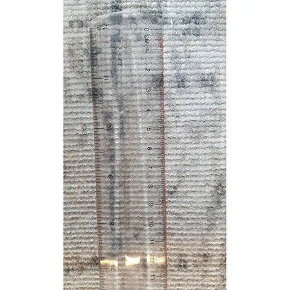 Measuring carpet thickness: beige-gray vintage fabric with a blue grid, measuring tape in the image