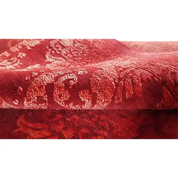 Red designer rug with a delicate pattern, dense pile structure along the edge