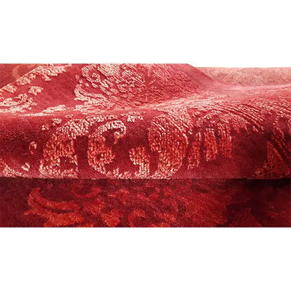 Red designer rug with a delicate pattern, dense pile structure along the edge