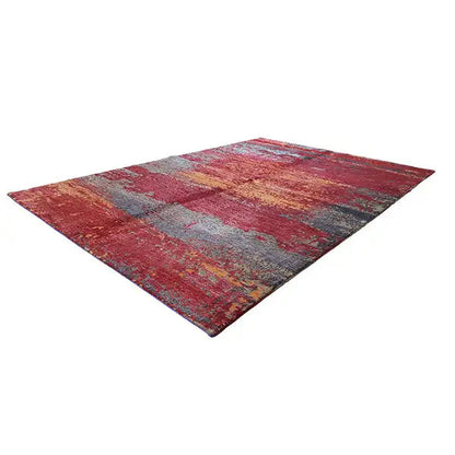Rug with an abstract pattern in red, gray, and blue, rectangular with frayed edges
