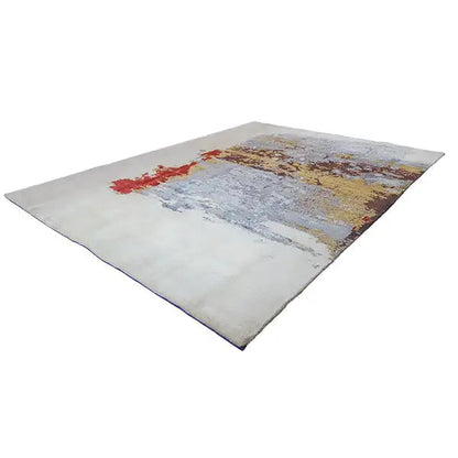 Designer rug at an angle, light gray with blue and yellow color splashes