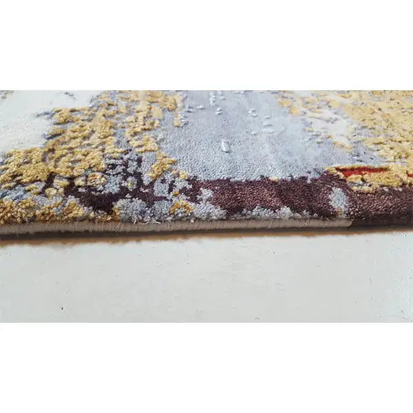Carpet edge in detail: patterned pile with a blue-gray and yellow-red color gradient