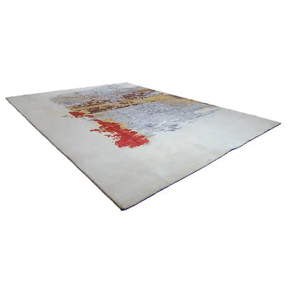 Designer rug in angled view, light gray with a red stripe and colorful patterned area