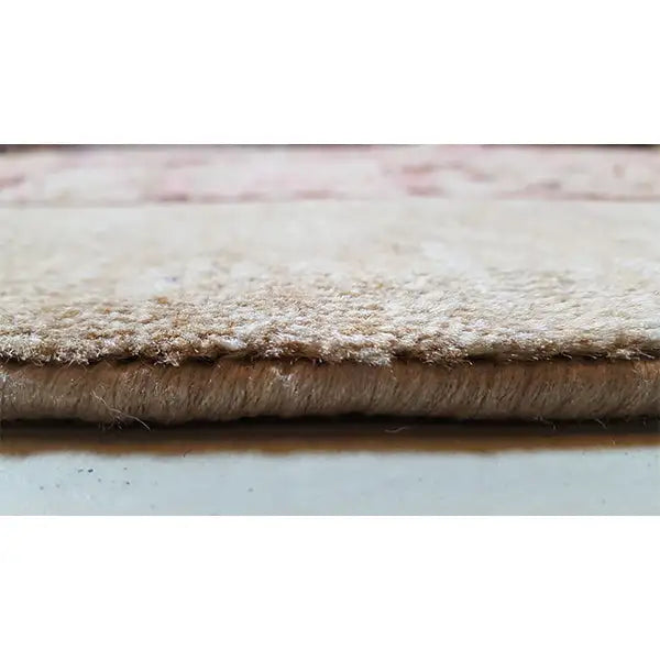Rug edge with dense pile, beige border and mottled textile pattern