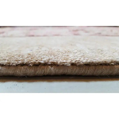 Rug edge with dense pile, beige border and mottled textile pattern