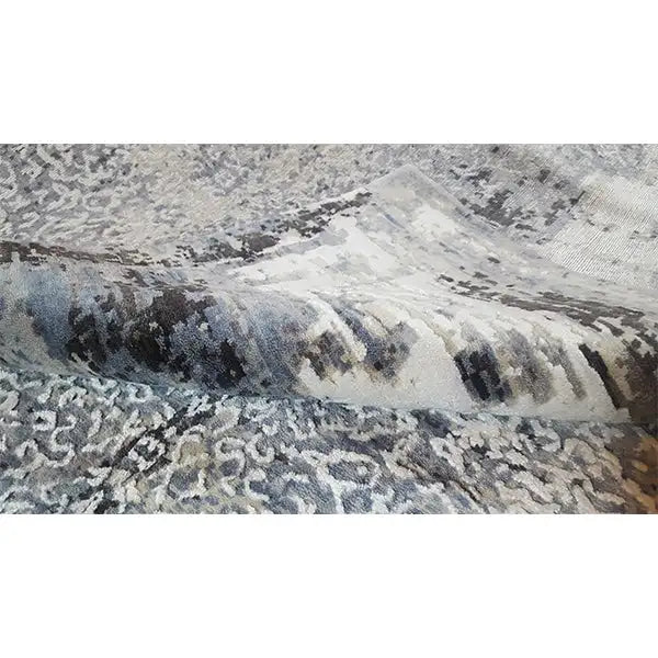 Carpet detail with blue-gray and beige patches of color, abstractly textured