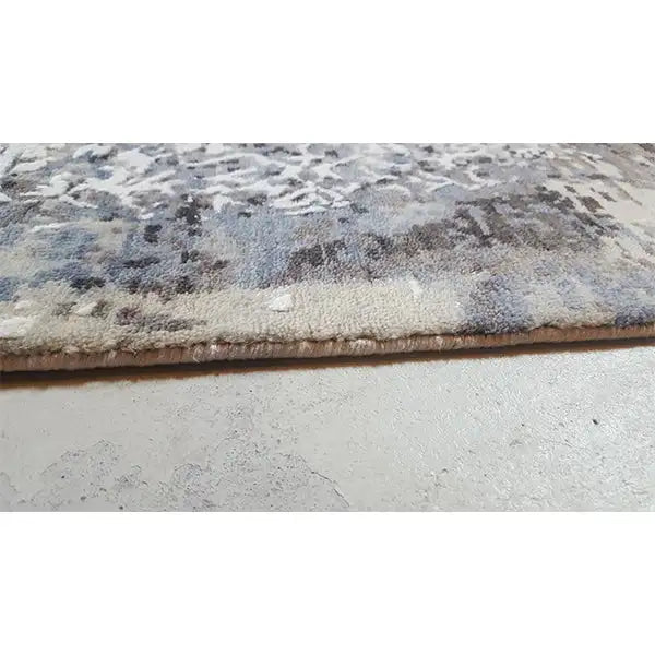Rug edge with a sturdy selvage and an abstract blue-gray pattern
