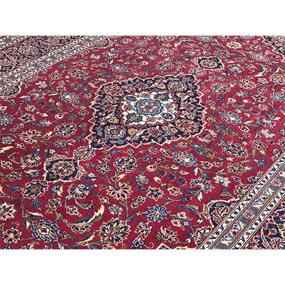 Carpet detail with a red background, blue border, and floral ornaments in the pattern