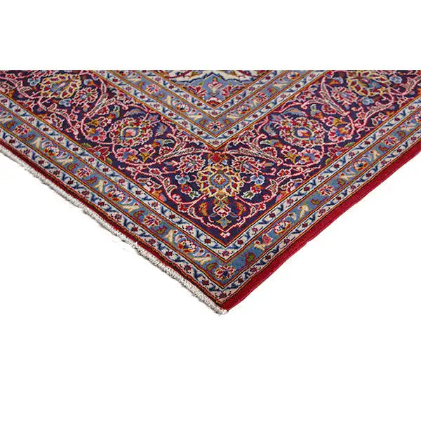 Tablecloth corner with border trim, red and blue ornaments, and fringe along the hem