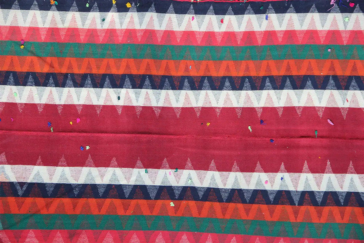 Jajim rug with a repeating zigzag pattern in blue, green, red, and cream
