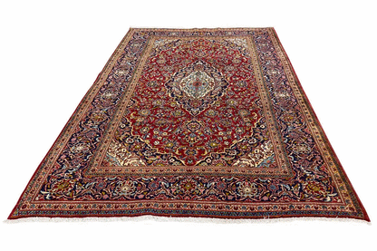 Red and multicolored oriental rug with a central medallion, surrounding border, and ornaments