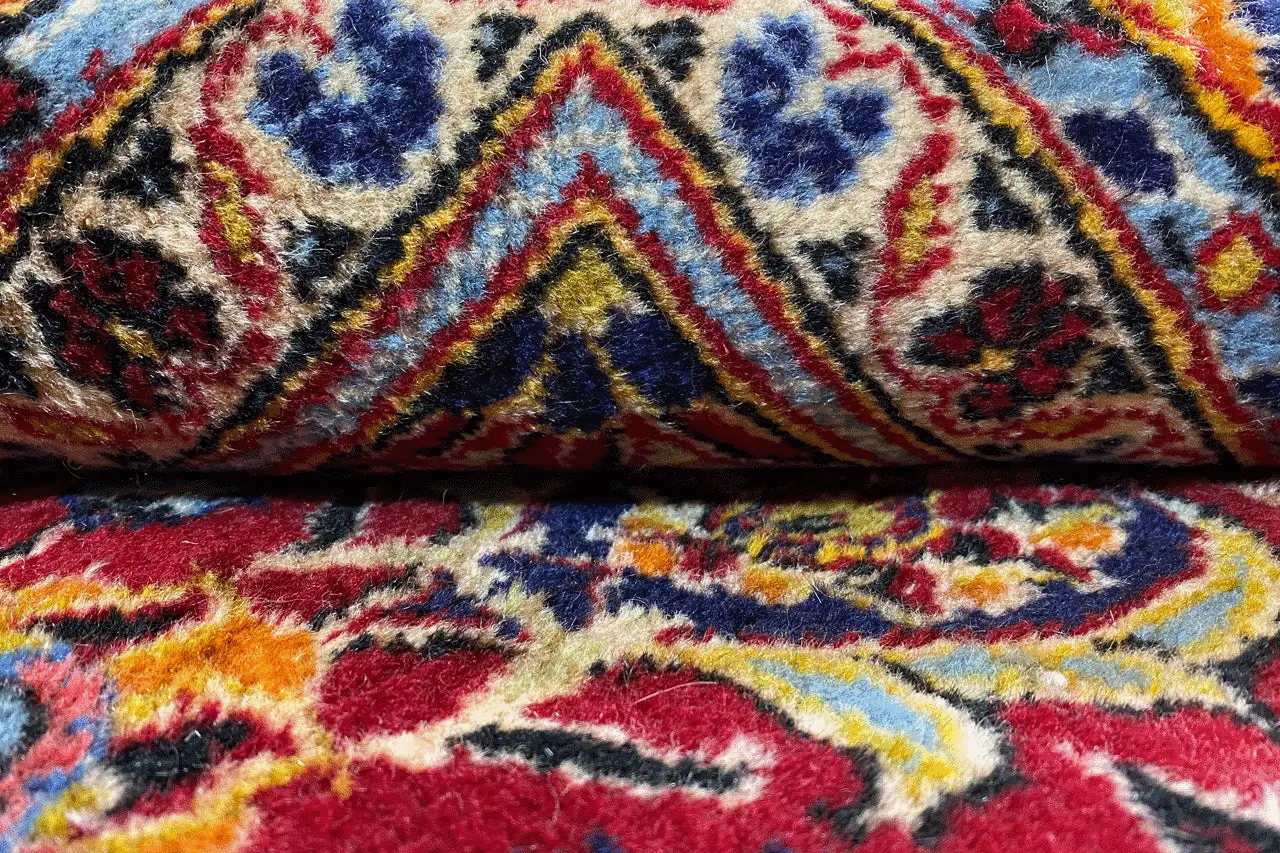 Close-up view of the oriental rug pattern in red, blue and yellow