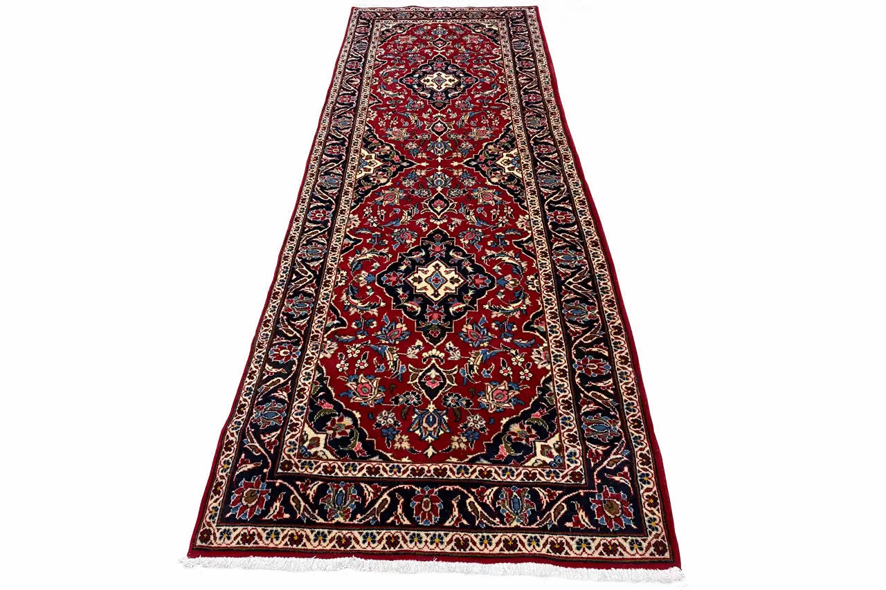 Red oriental rug with a vine and medallion pattern and blue border
