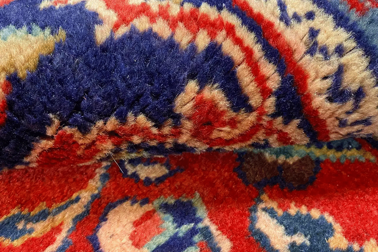 Close-up: red carpet with blue and beige decorative ornaments and pile