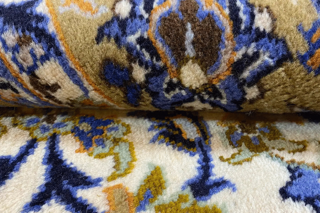Keshan carpet pile with a blue ornamental pattern on a beige background