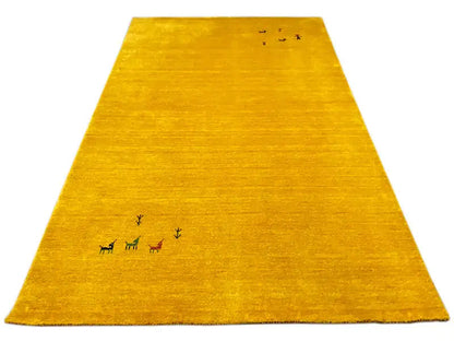 Gabbeh rug in yellow with small animal and plant motifs along the edge