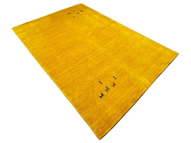 Yellow Gabbeh rug, photographed from the corner, subtle animal motifs in the center