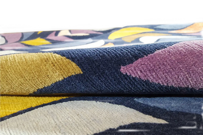 Rug with a wave pattern in blue, yellow, violet, and cream, laid flat
