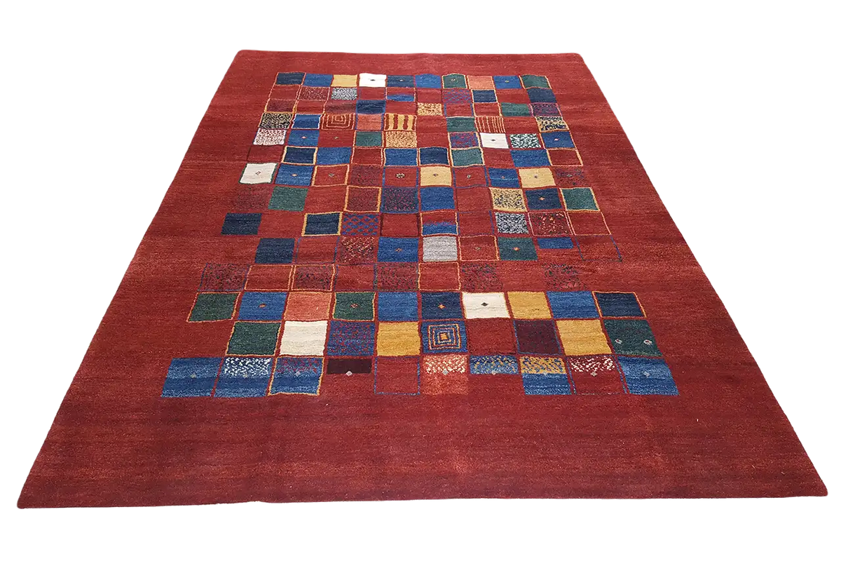 Gabbeh rug: symmetrical patchwork in blue, yellow and white on red