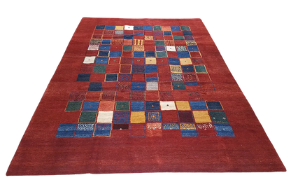 Gabbeh rug: symmetrical patchwork in blue, yellow and white on red