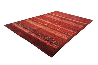 Gabbeh rug with reddish pile, even stripes, and golden-brown color accents.