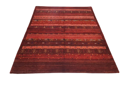 Gabbeh rug with a wide central stripe and horizontal bands in shades of red.